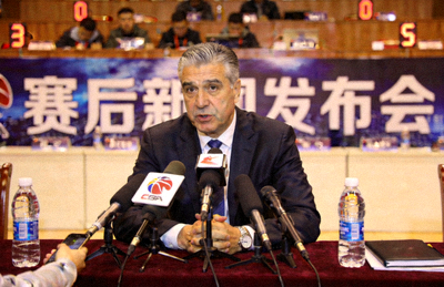篮球教练在赛后新闻发布会上接受媒体采访的现场照片